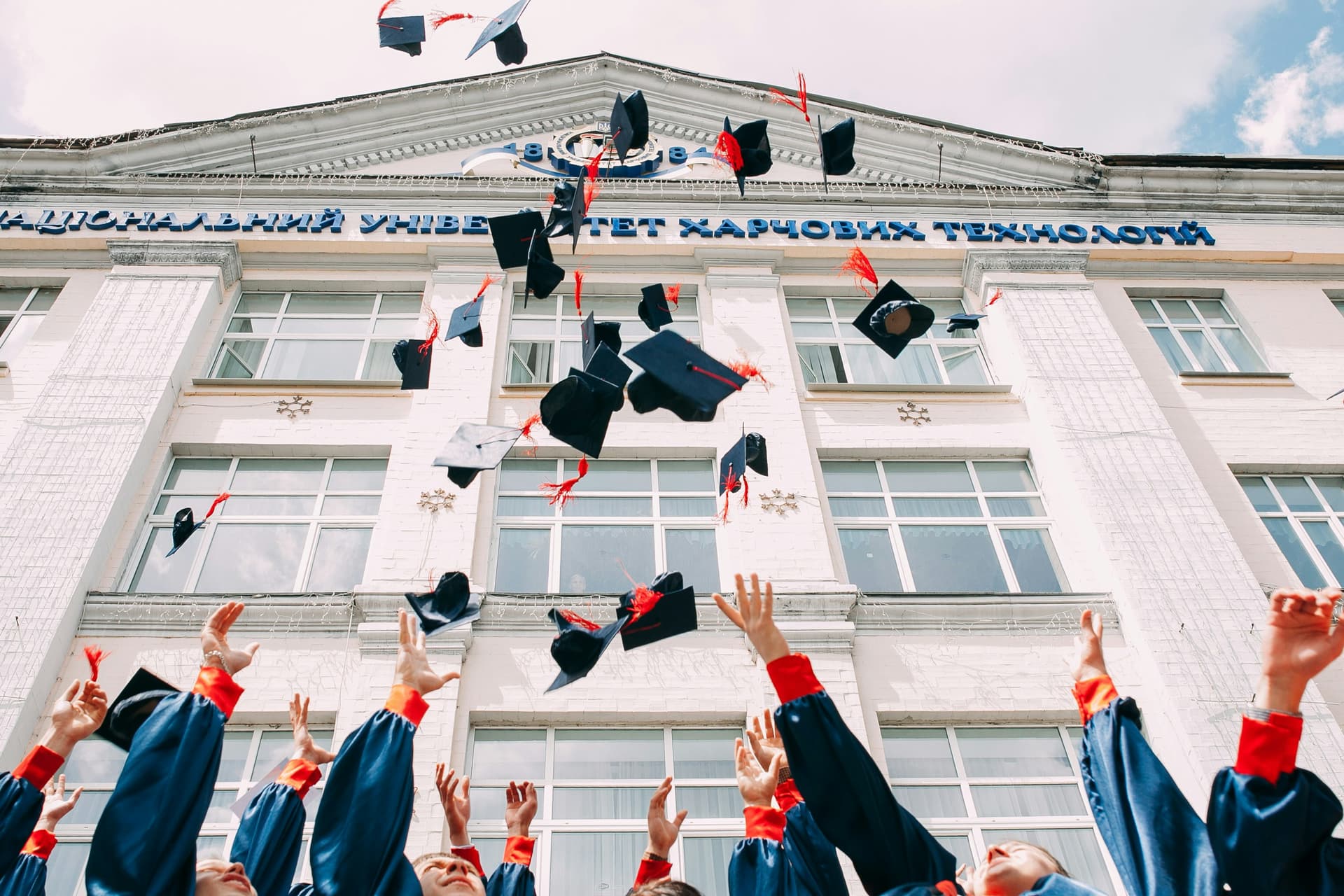 Diverse graduates throwing caps in celebration
